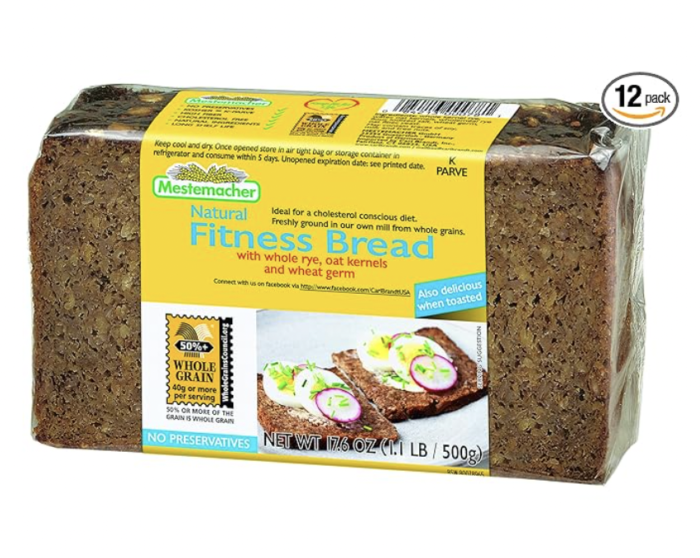 Slice of Mestemacher Low-Calorie Bread on a wooden cutting board, showcasing its hearty texture and whole grain ingredients, ideal for healthy meals and snacks