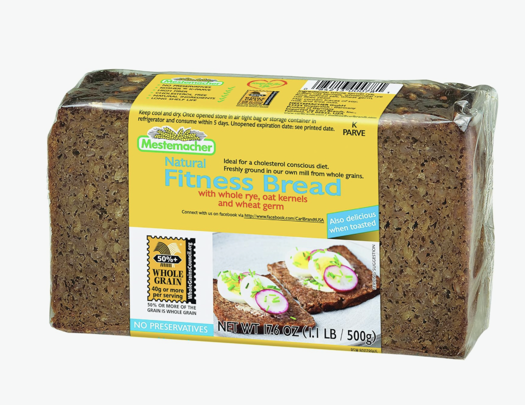 Slice of Mestemacher Low-Calorie Bread on a wooden cutting board, showcasing its hearty texture and whole grain ingredients, ideal for healthy meals and snacks